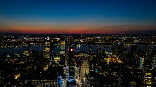 High angle view of illuminated city against sky at night