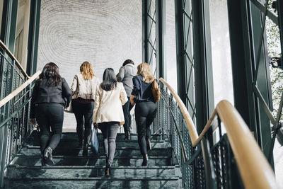 Low angle view of multi-ethnic female entrepreneurs moving up on staircase in office