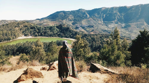 Rear view of woman standing on mountain