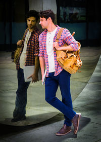 Young man looking at the mirror on the street, sad, thinking, lost in thought.