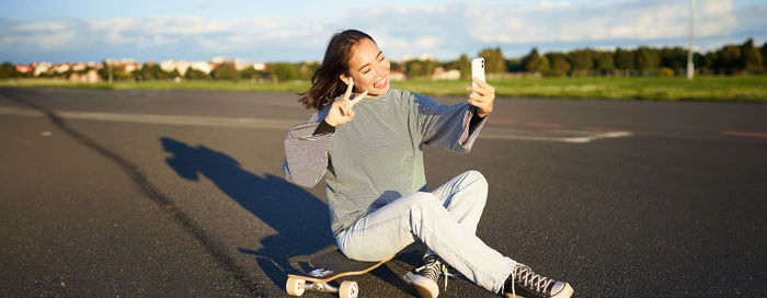 Portrait of young woman walking on road