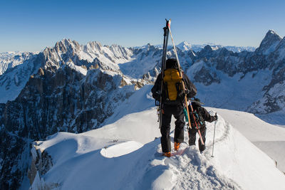 Tourists skiing on snow covered mountain