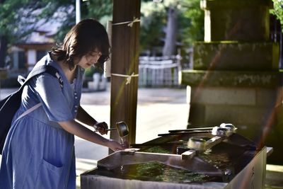 Side view of woman standing by water