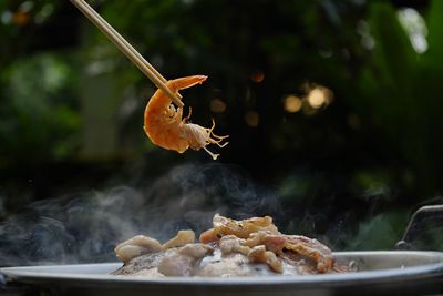 Thailand style bbq grill on a charcoal fire that is located on the bottom with pork, shrimp, squid 