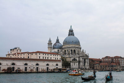 View of boats in canal against sky