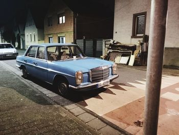 Car parked on street by buildings in city