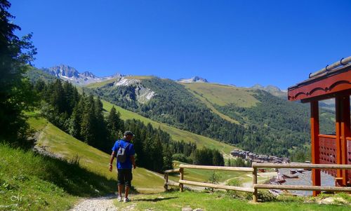 Man standing on mountain against clear blue sky