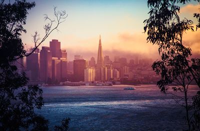 View of buildings in city at sunset