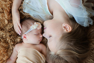 Directly above shot of mother and baby sleeping on fluffy bed