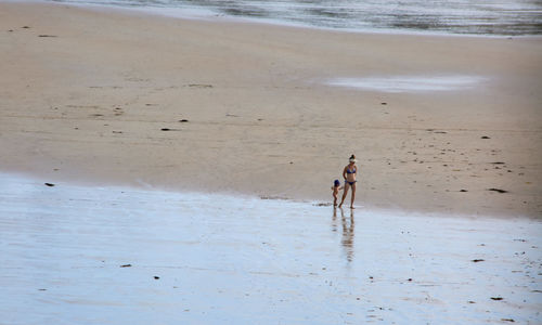 Rear view of woman walking on beach