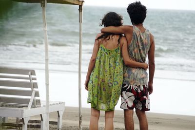 Rear view of loving couple standing at beach