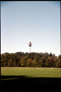 Tower amidst trees and buildings against sky