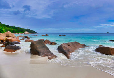 Rocks on beach against sky