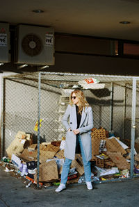 Portrait of young woman standing against wall