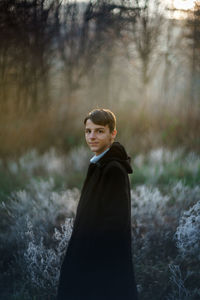 Portrait of young woman standing in forest