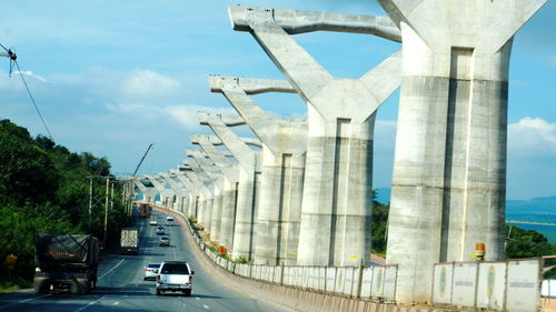 Cars on road against sky in city