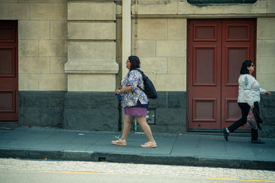 Full length of woman walking against building