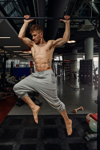 Shirtless man exercising in gym