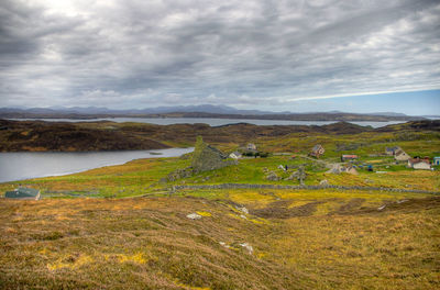 Scenic view of landscape and mountains against cloudy sky