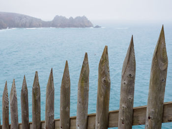 Panoramic view of wooden posts in sea against sky
