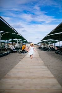 Man walking on bridge against sky