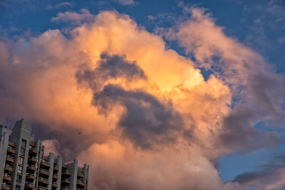 Low angle view of buildings against dramatic sky