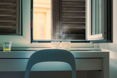Empty chairs and table by window at home