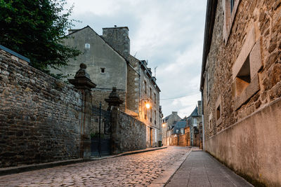 Old cobblestoned street with stone medieval houses in the town centre of dinan, french brittany
