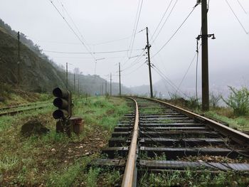 Railroad track amidst trees against sky