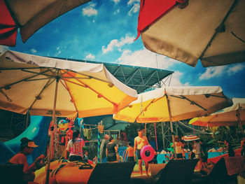 Multi colored flags at amusement park against sky