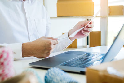 Midsection of woman working with laptop