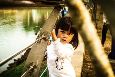 Portrait of cute girl standing by railing