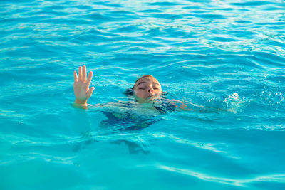 Cute girl drowning in swimming pool