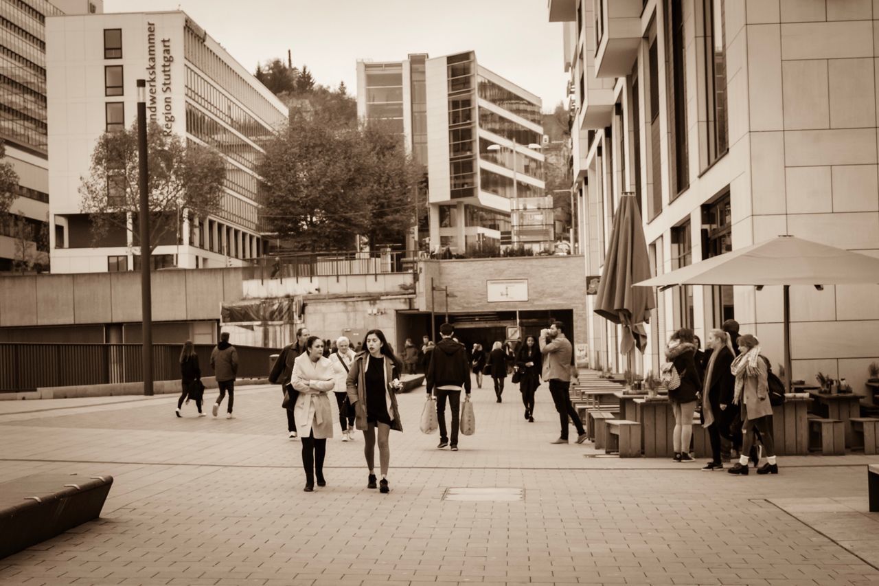 PEOPLE WALKING ON ROAD IN CITY