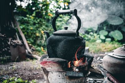 Close-up of kettle on camping stove in forest