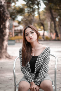 Portrait of young woman sitting outdoors