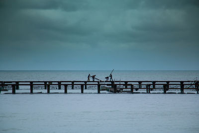 View of fence on sea against sky