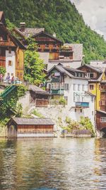 Houses by river and buildings in city