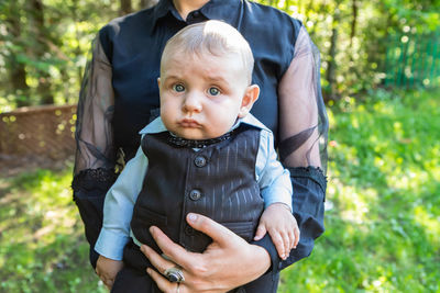 Midsection of mother and boy standing outdoors