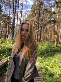 Portrait of young woman standing in forest