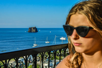 Portrait of woman in sunglasses against sea