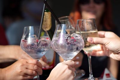 Closeup of cocktail in elegant glasses - group of people toasting