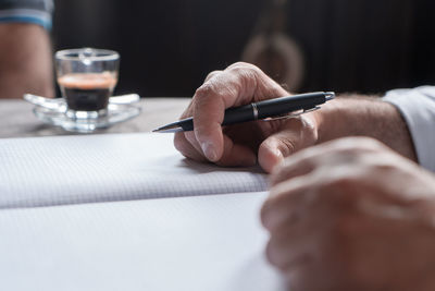 Business lunch - close up of a businessman hand holding a pen illustrating marketing business