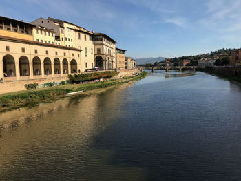 View of river by buildings against sky