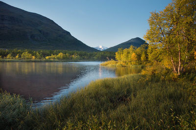 Scenic view of lake and mountains against clear sky
