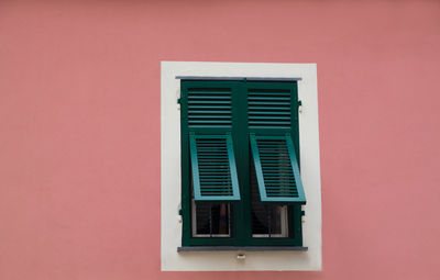 Close-up of green window on the pink wall