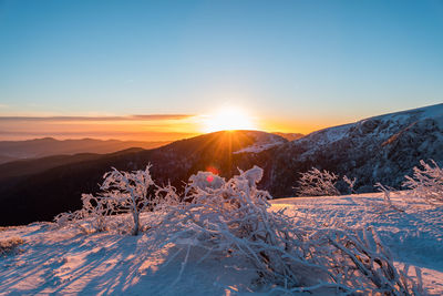 Scenic view of snowcapped mountains against sky during sunset