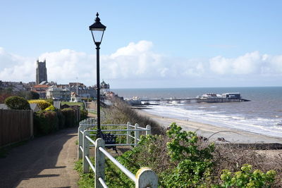 Street by sea against sky in city