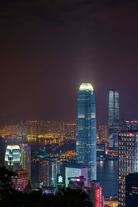 Illuminated buildings in city against sky at night