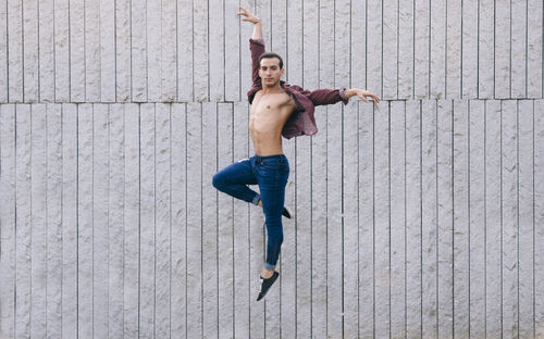 Portrait of man dancing against wall